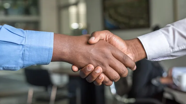A homeowner shaking hands with a trusted handyman at a Kansas City front door