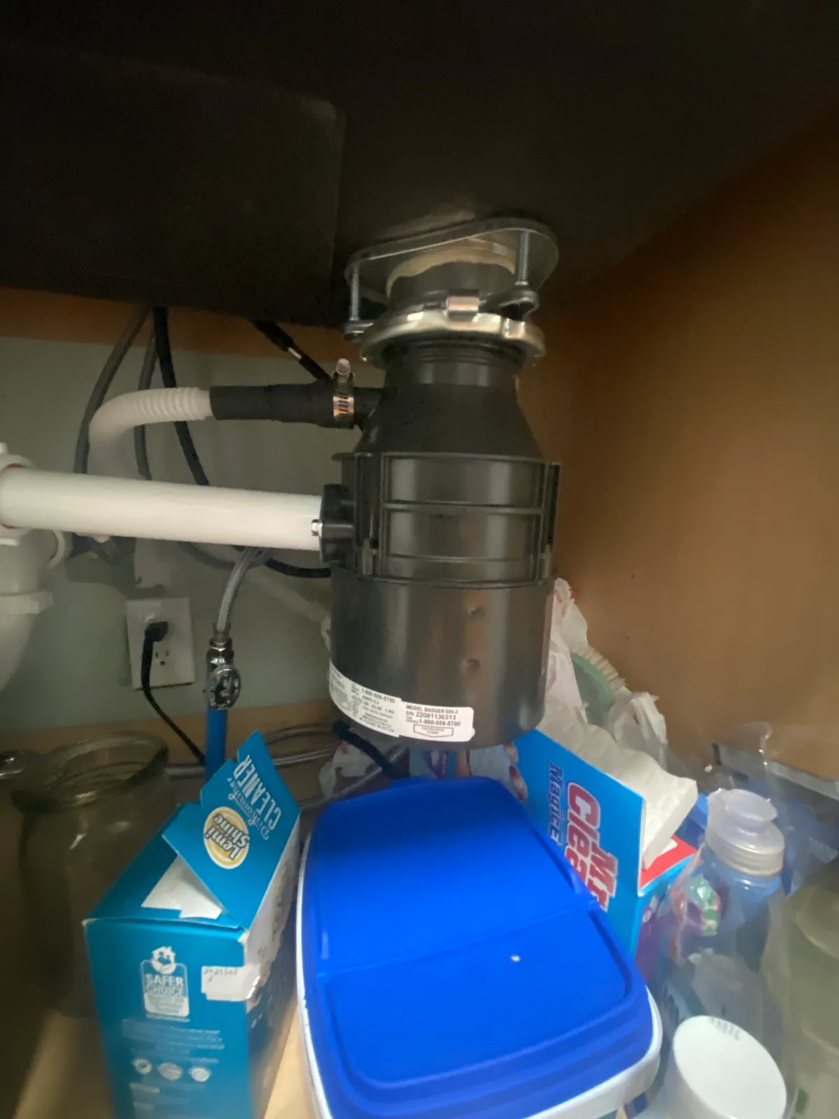 New garbage disposal installed and plumbed under a kitchen sink