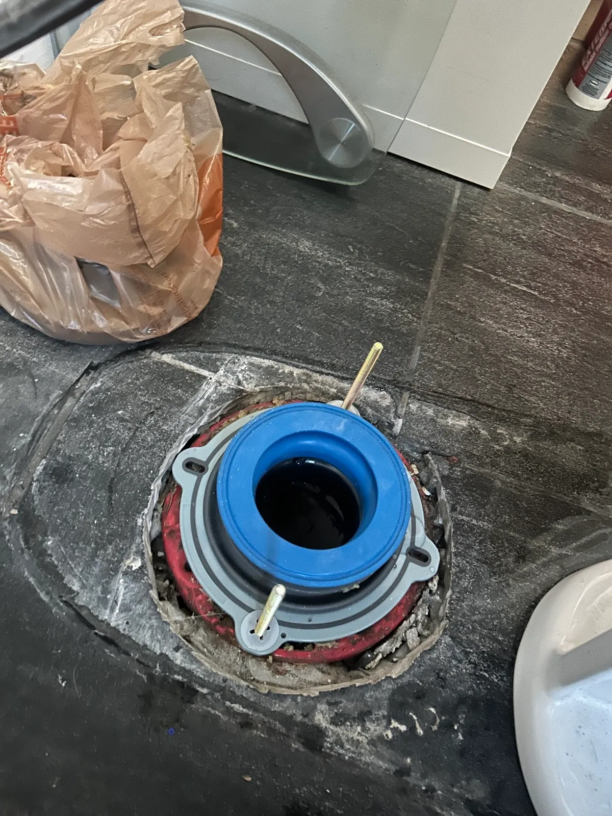 Toilet reset on a fresh wax ring, leveled and sealed at the base